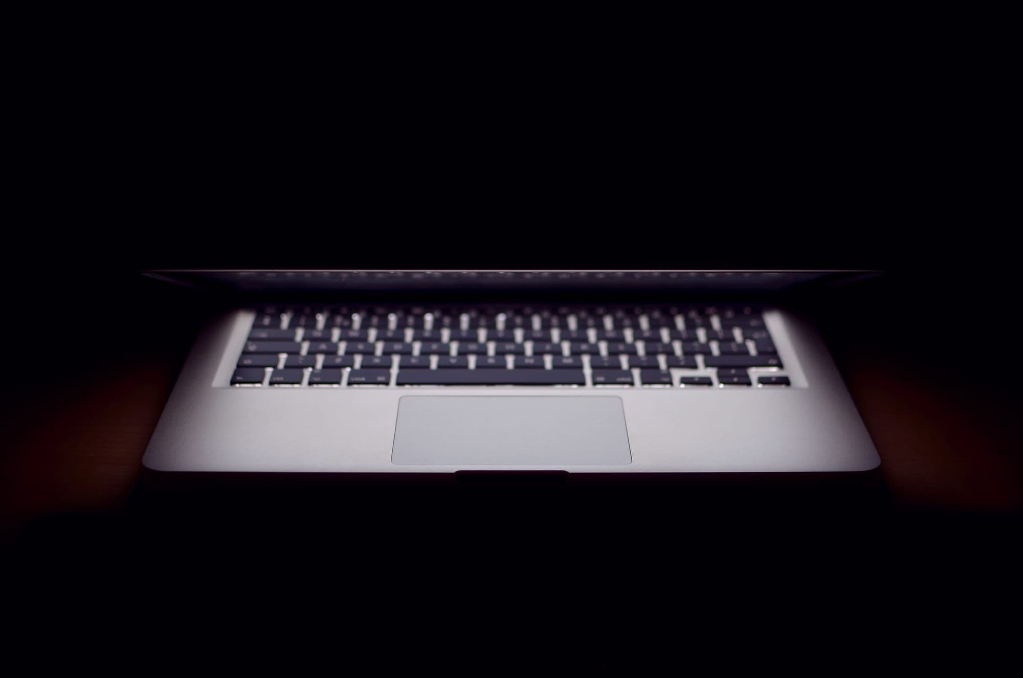 Laptop glowing in a dark room
