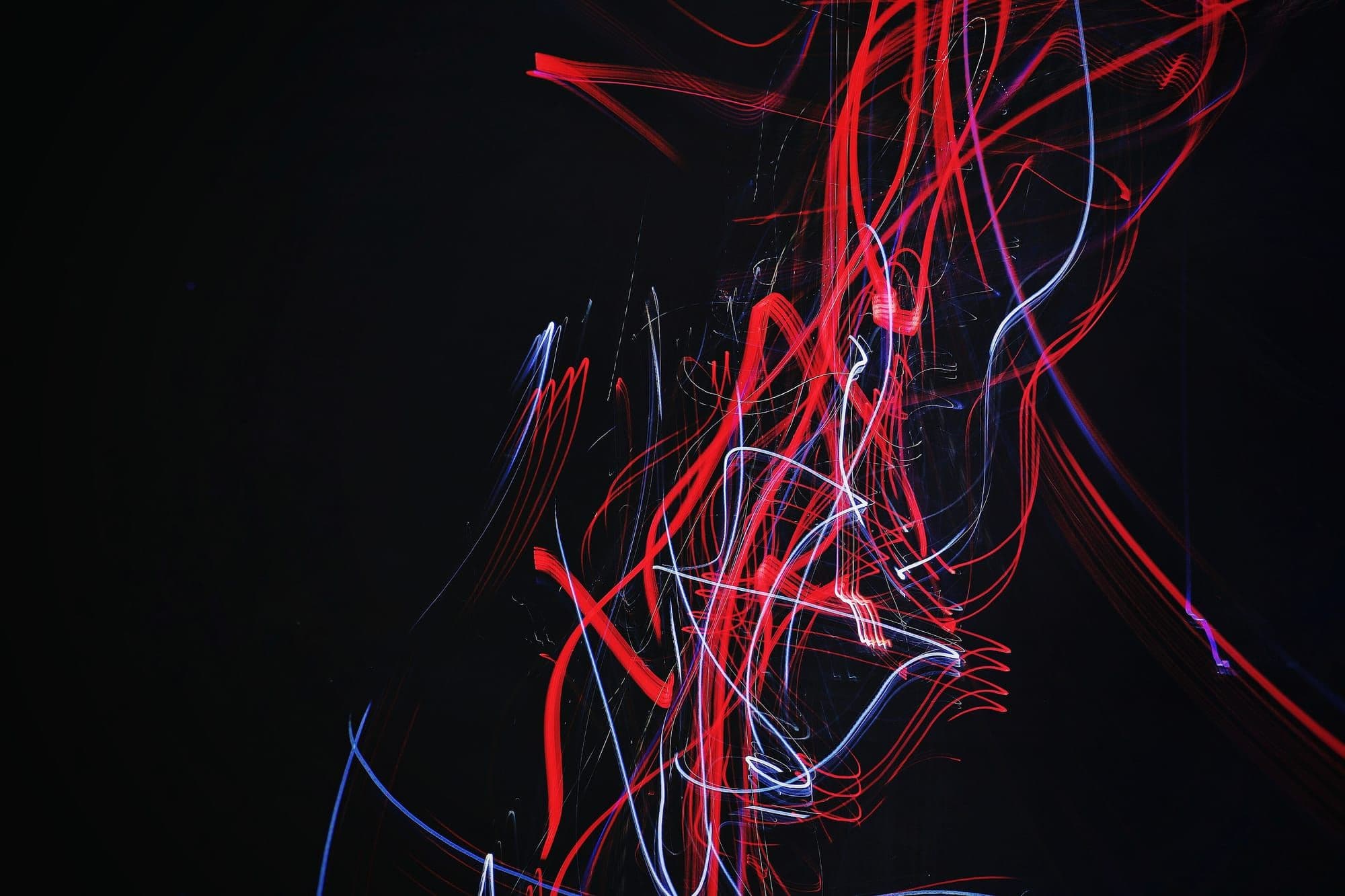 Red and blue light trails on a black background